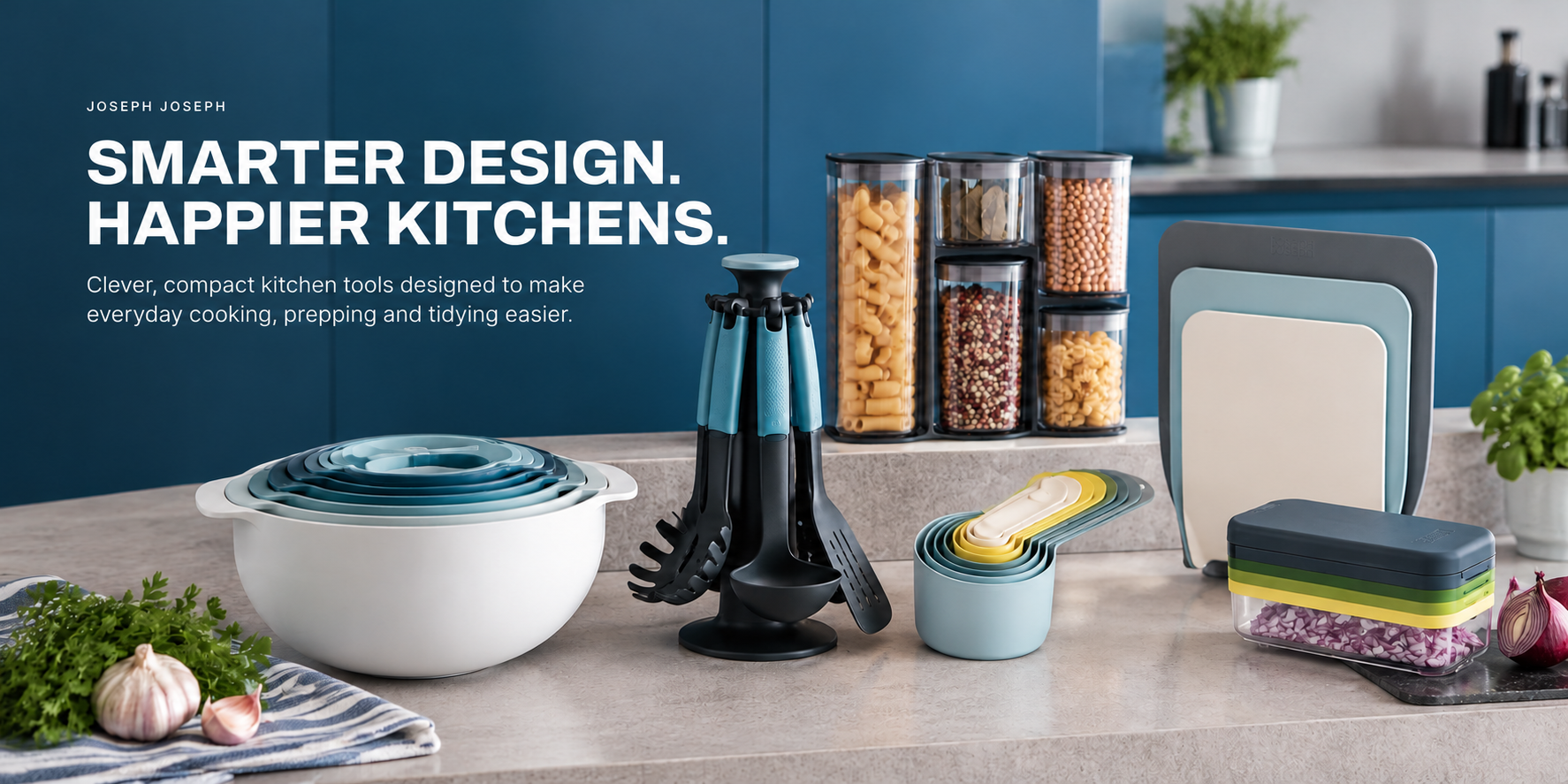 Joseph Joseph utensils, nesting bowls, storage jars and food containers on a stone countertop — Smarter design. Happier kitchens.