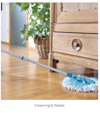 A microfibre mop being pushed across a warm wooden floor beside a wooden dresser and potted plant