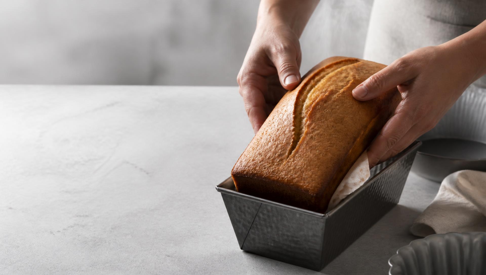 Baking tins, a mixing bowl and a cooling rack laid out on a floured counter