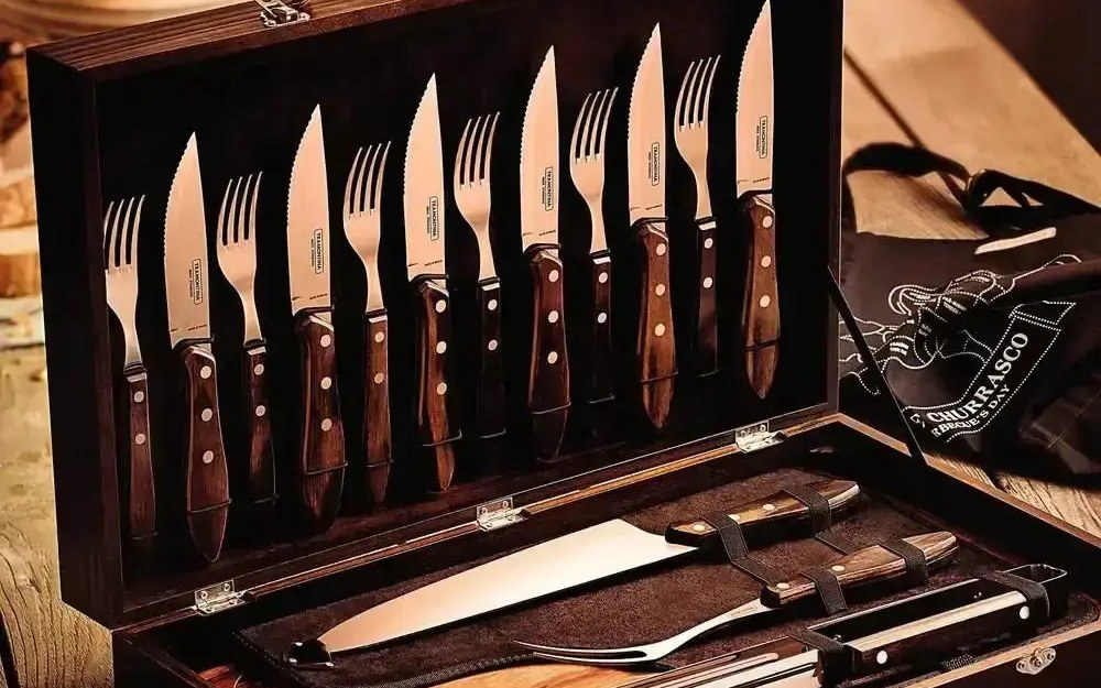 Tramontina Churrasco carving and braai set laid out in a wooden case on a rustic table