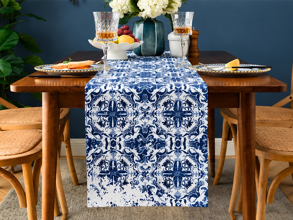 A blue-and-white printed table runner on a dressed wooden dining table