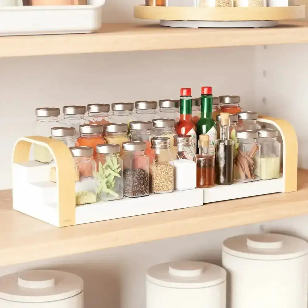 Spice rack with various jars on a kitchen shelf