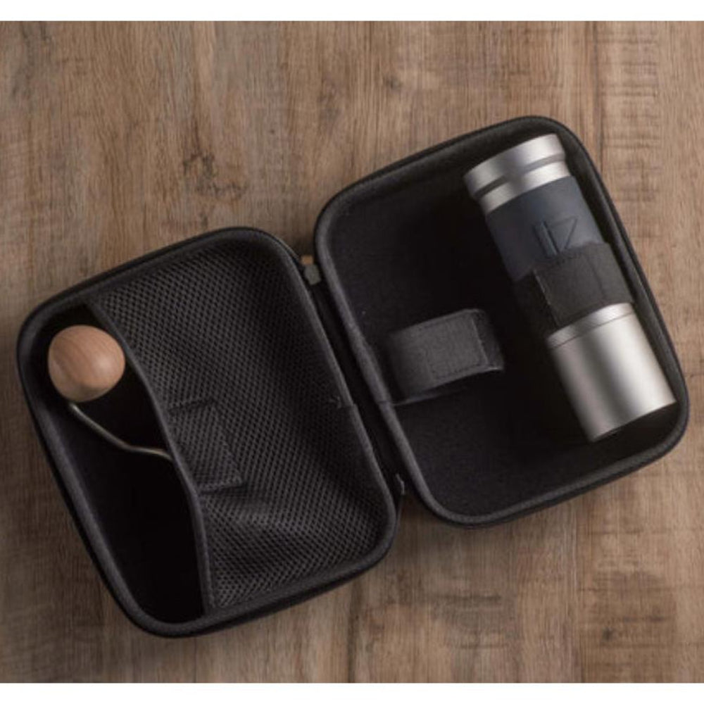 Black travel mug with wooden ball in a black carrying case on a wooden surface