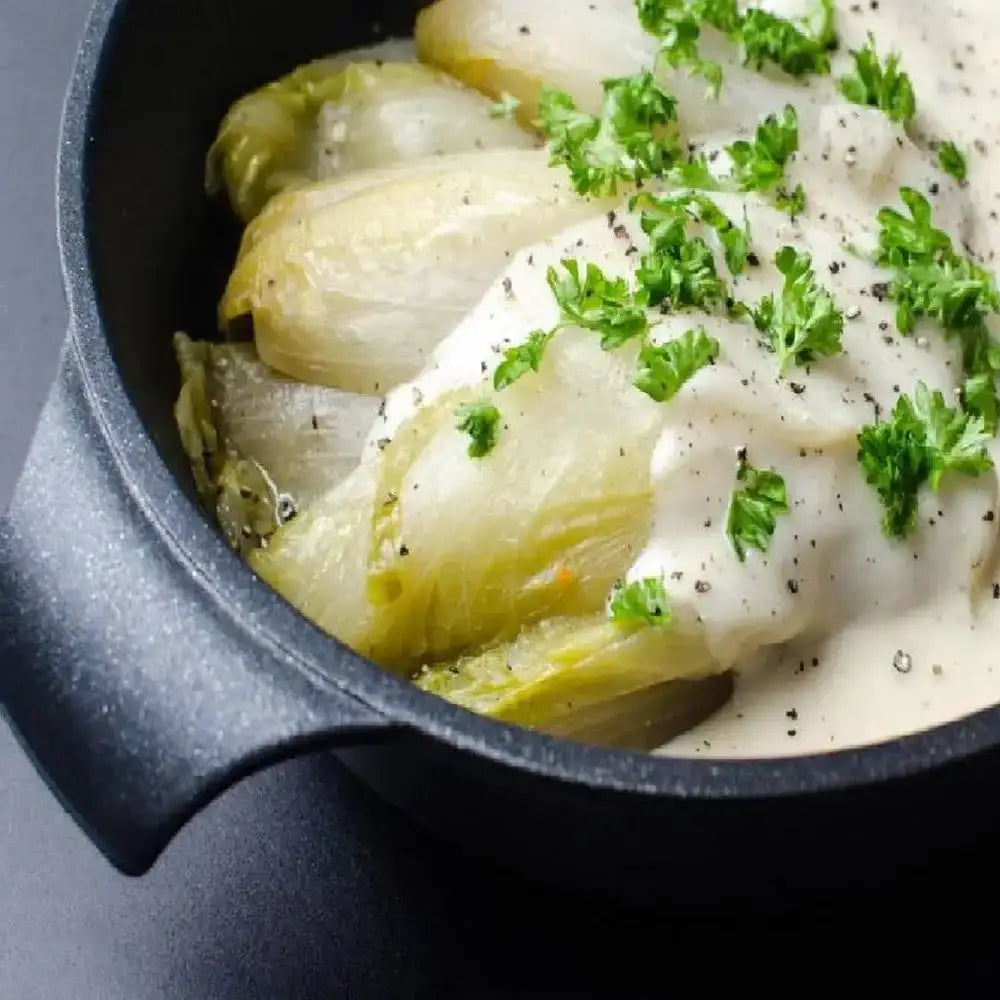 Steamed cabbage with cream sauce and parsley in a black dish