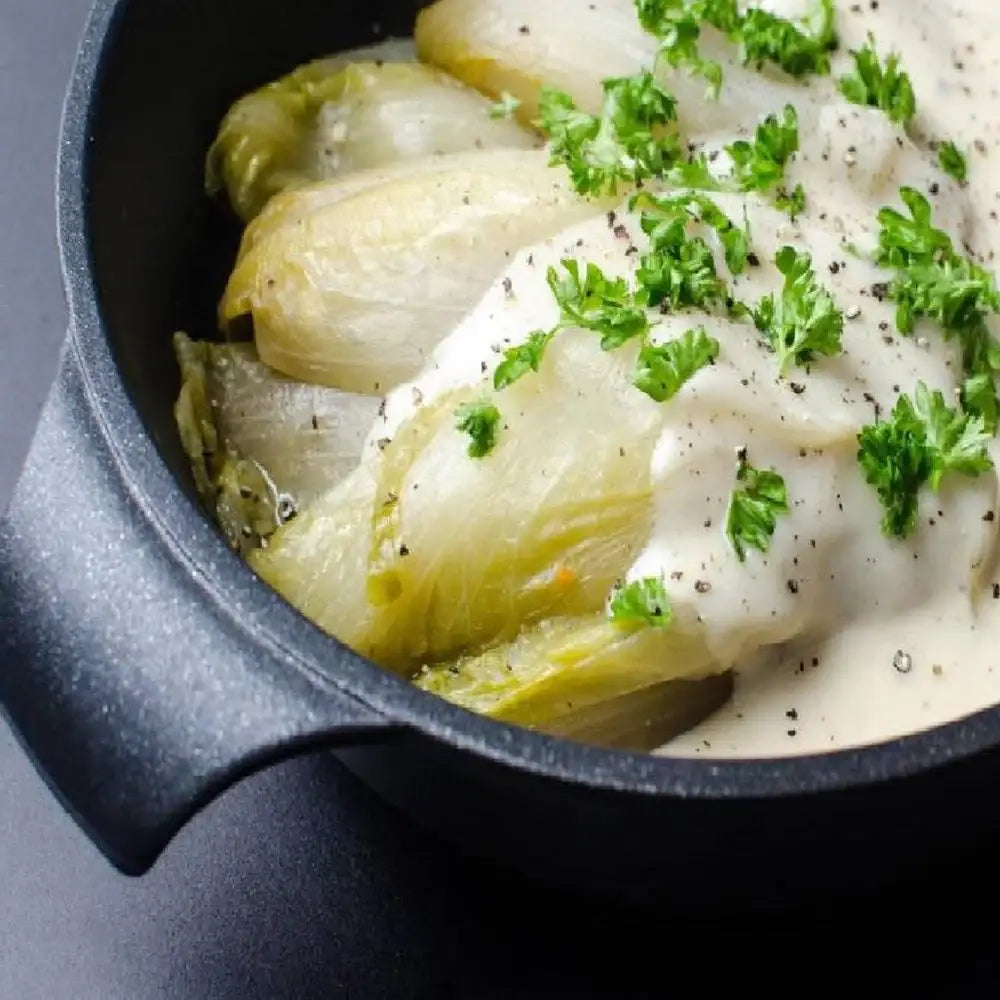 Steamed cabbage with cream sauce and parsley in a black dish