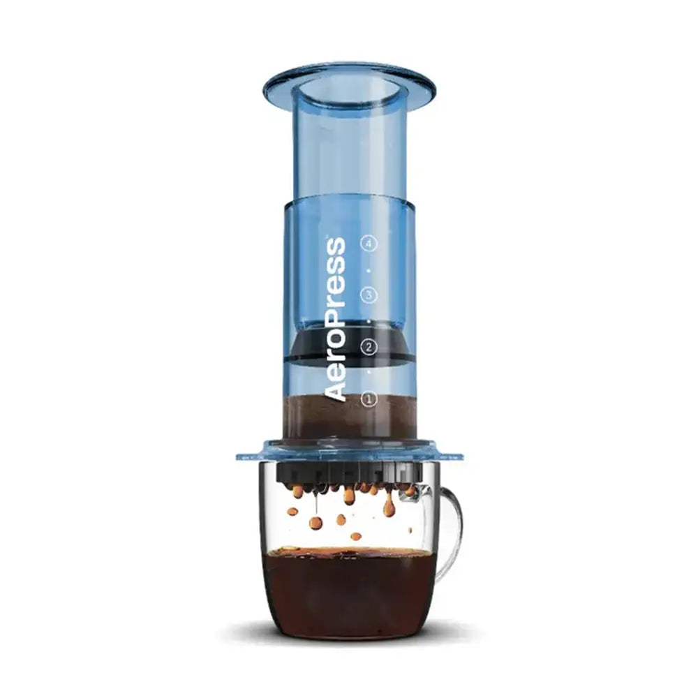 Aeropress coffee maker with a clear container and blue top on a white background