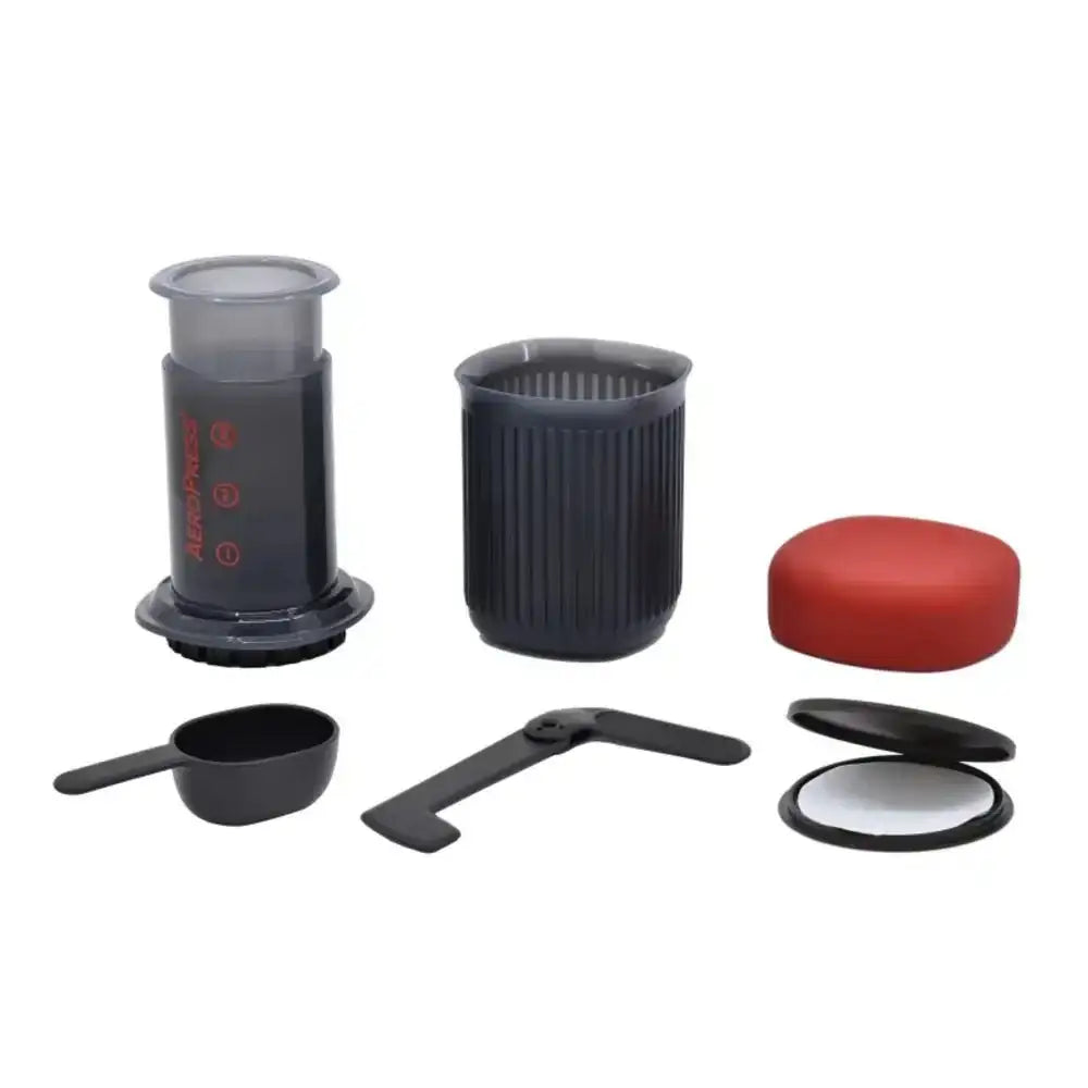 Set of coffee brewing components including a black container, red lid, and other accessories on a white background.