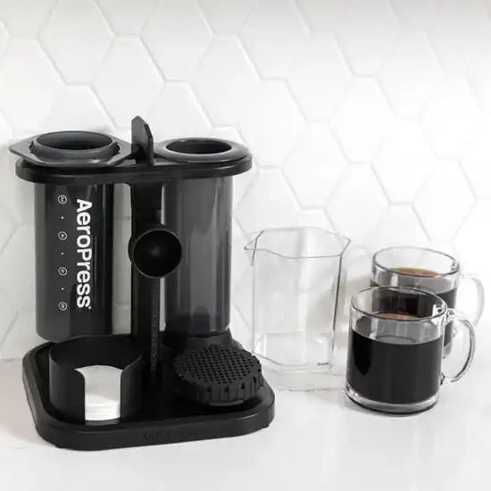 Aeropress compact organizer stand with coffee accessories and mugs on kitchen counter