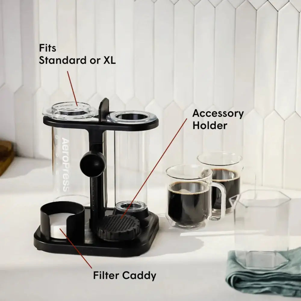 Black coffee accessory holder with labeled parts on a kitchen counter.