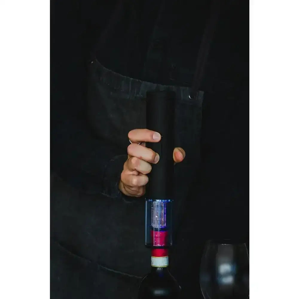 Person using a wine bottle opener on a dark background