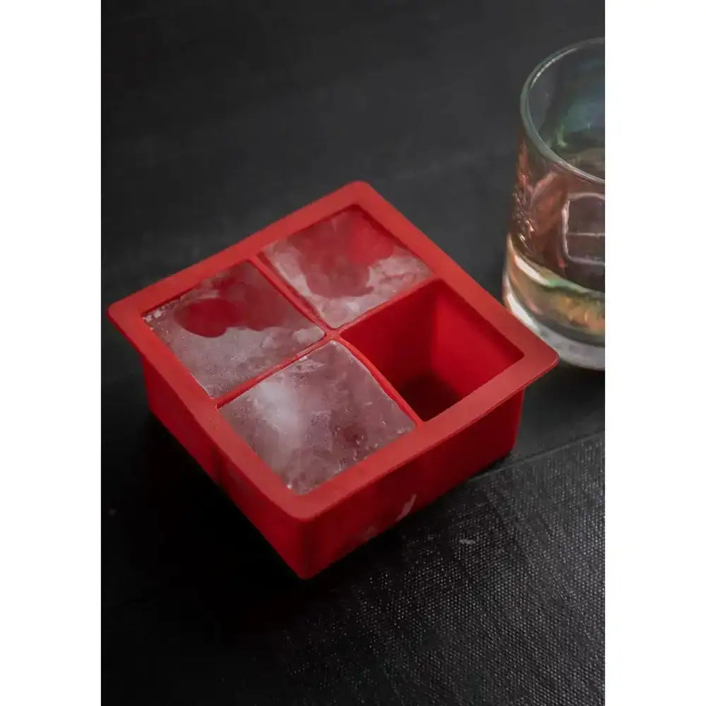 Red silicone jumbo ice cube tray by barcraft with four square compartments three partially filled with frozen water