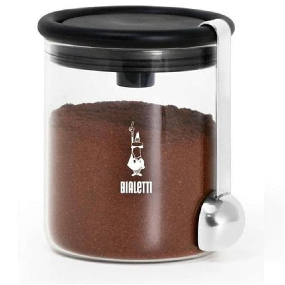 Glass container with coffee grounds and Bialetti logo on a white background