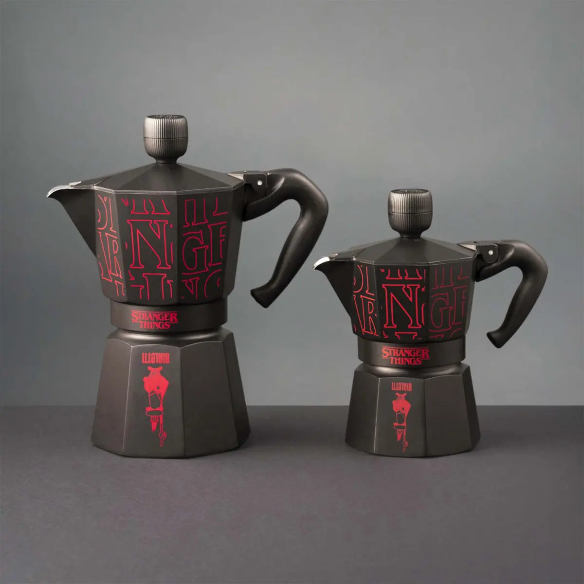 Two black coffee pots with red text on a gray background