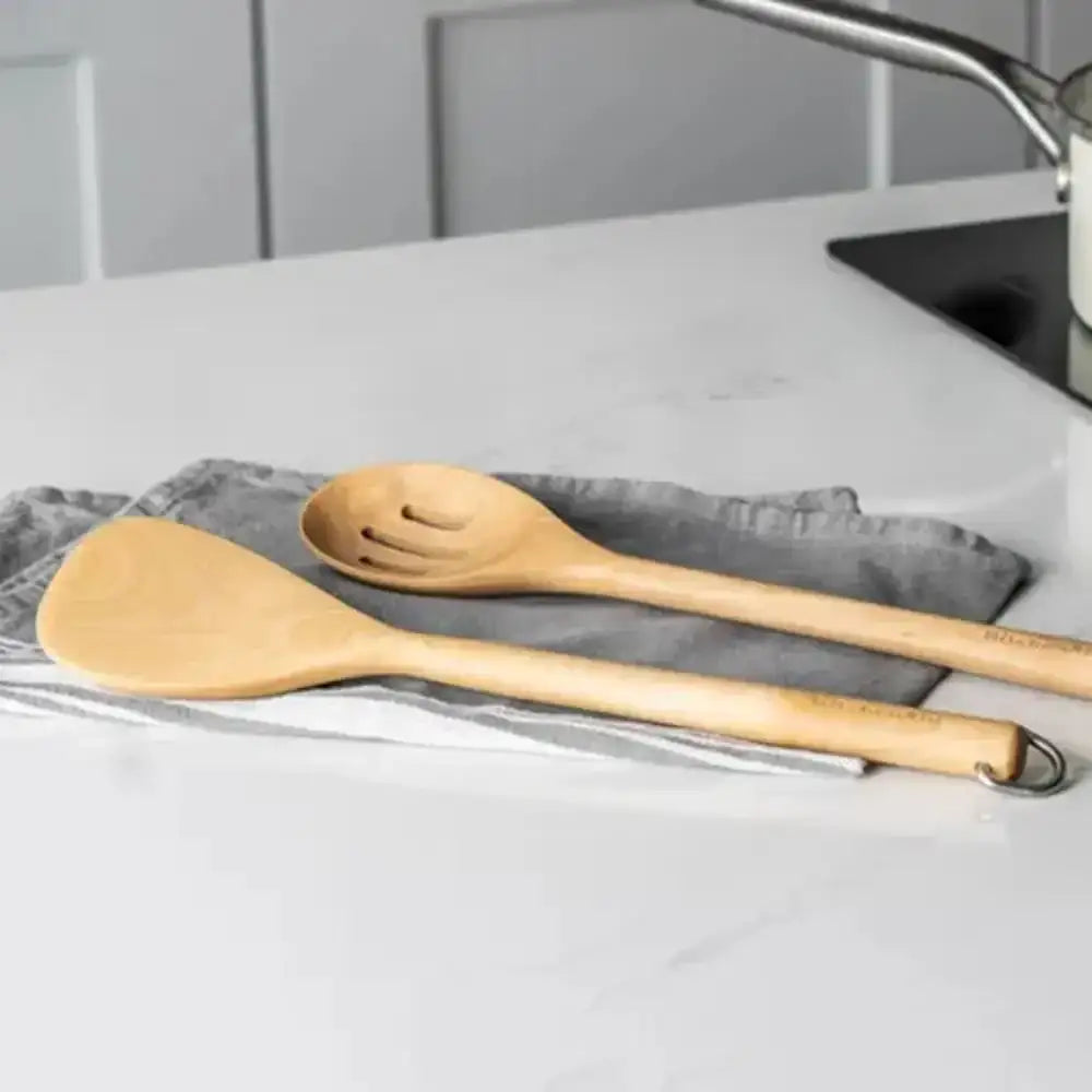 Two wooden utensils on a gray towel with a neutral background