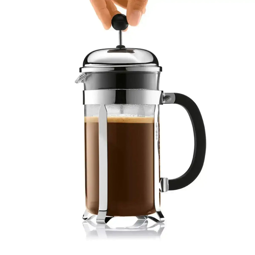 French press with coffee being pressed, on a white background