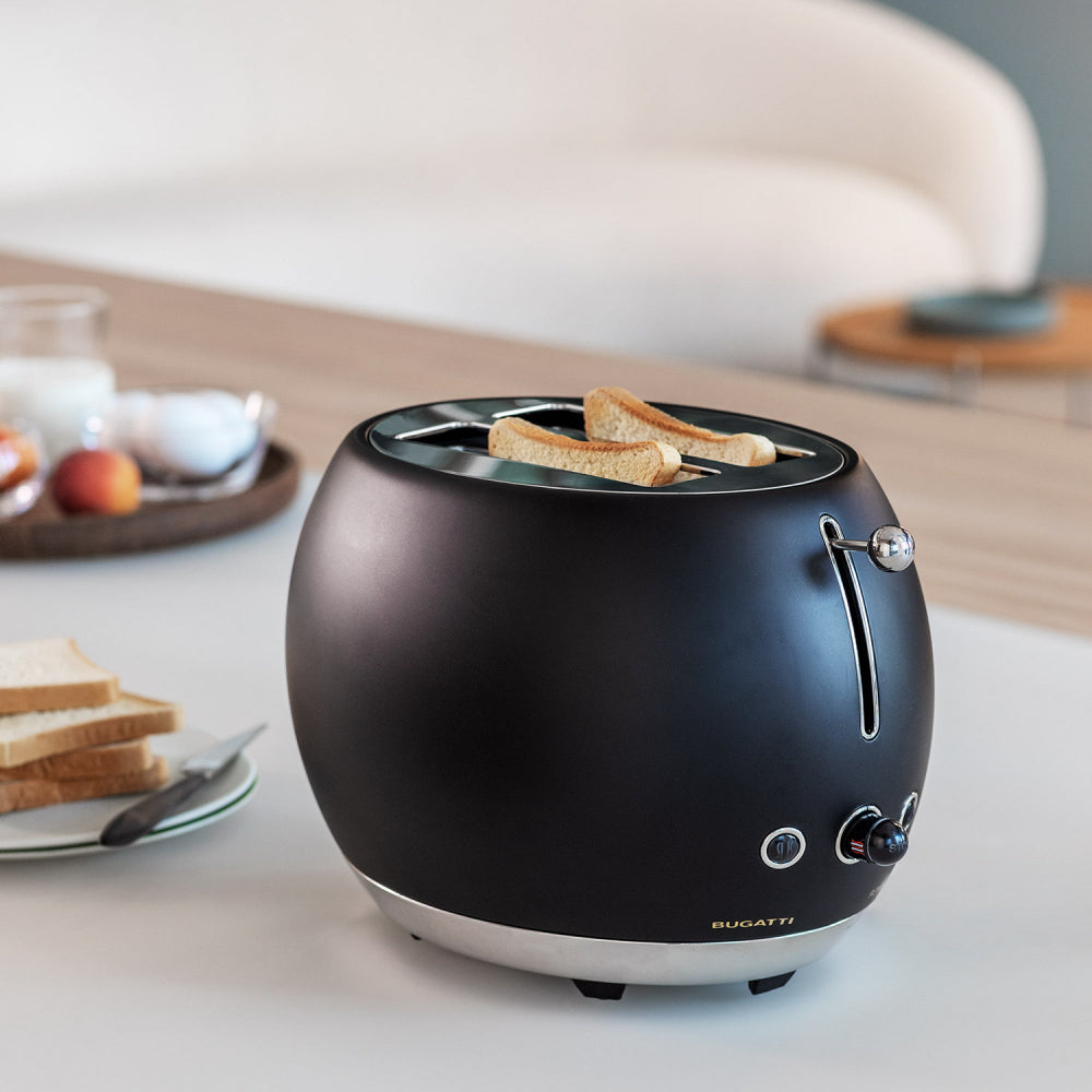 Black toaster with toast on a white surface 