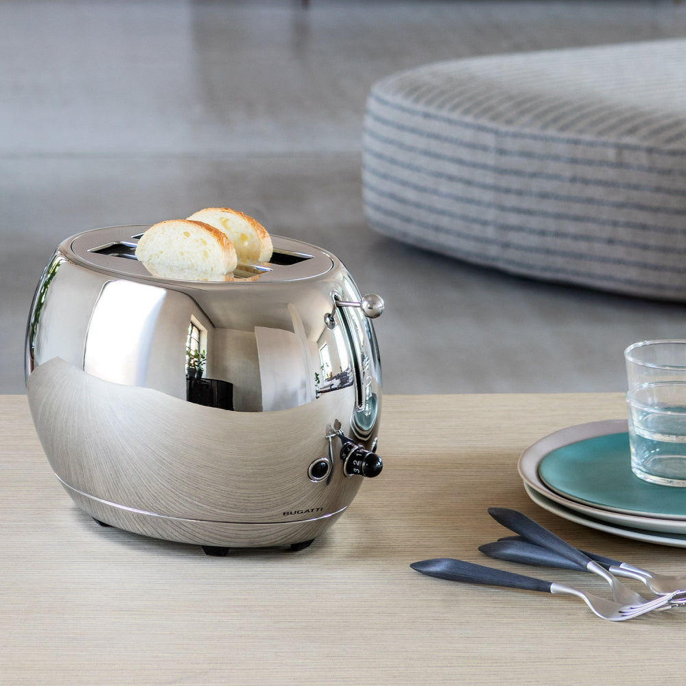 Stainless steel toaster with toast on a wooden surface 