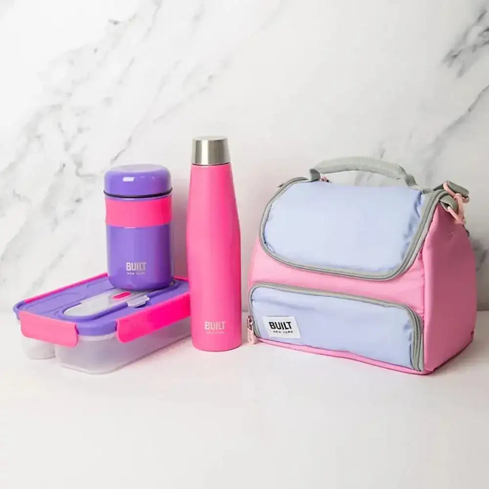 Pink and purple BUILT lunch bag, bottle, and container on a white surface with marble background