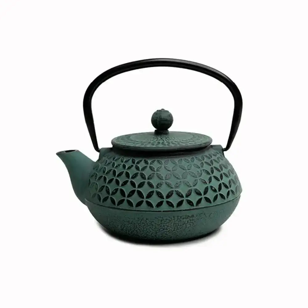 Green cast iron teapot with decorative lid on a white background