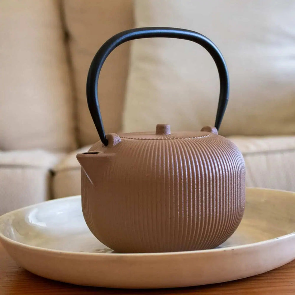 Brown textured teapot on a plate with a blurred background 