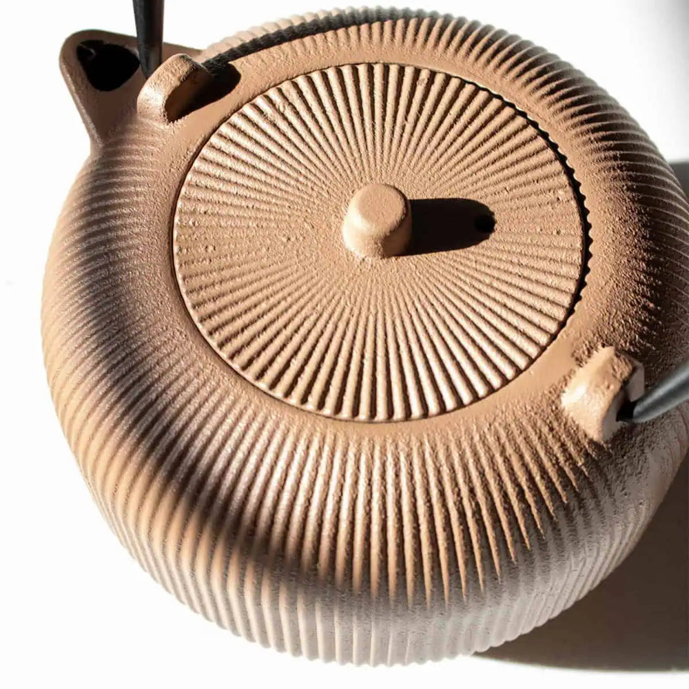 Close up of a brown textured teapot on a white background