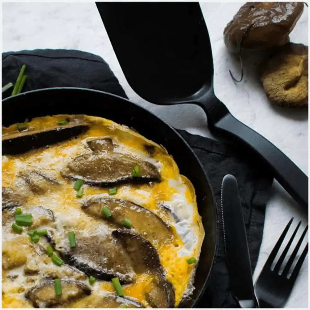 Frittata with mushrooms in a skillet on a marble surface
