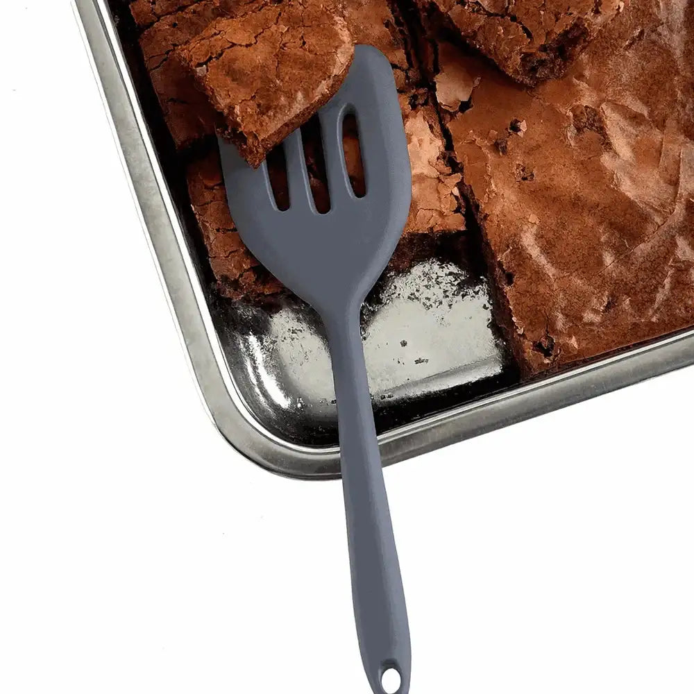 Gray spatula on a tray of brownies