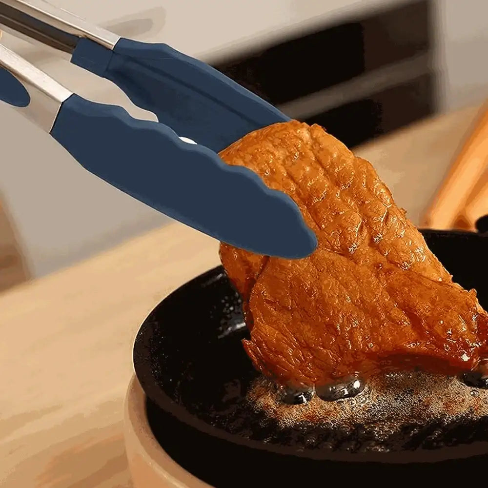 Close up of tongs holding a piece of meat
