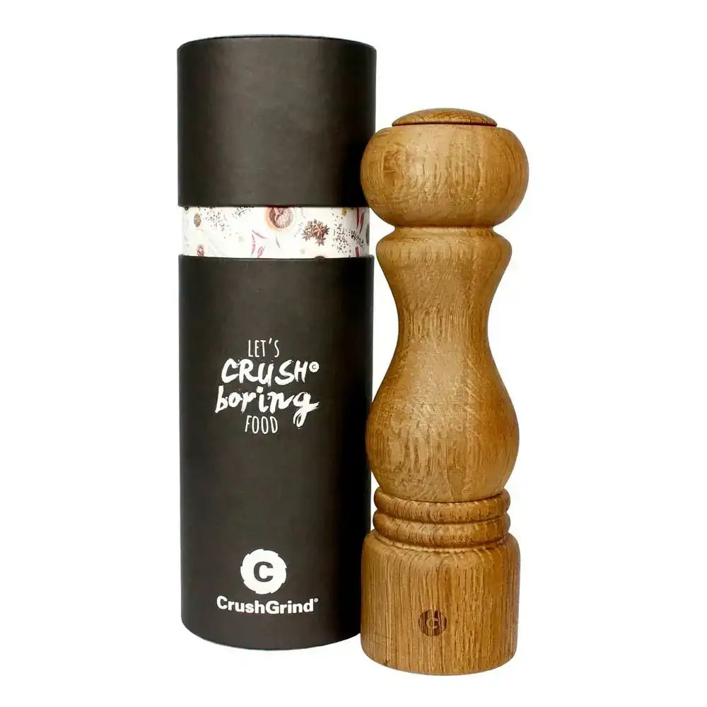 Wooden pepper grinder with black cylindrical packaging featuring text and branding.