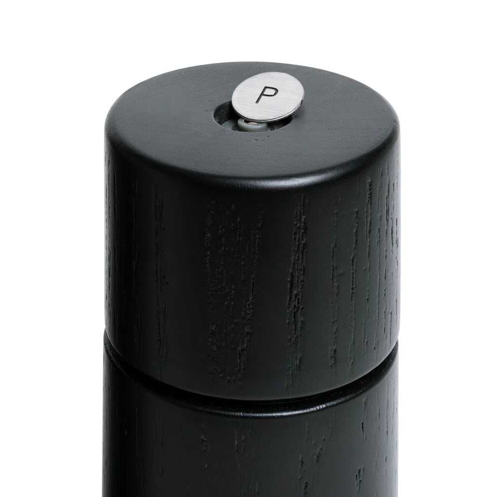 Black pepper grinder with a silver top on a white background