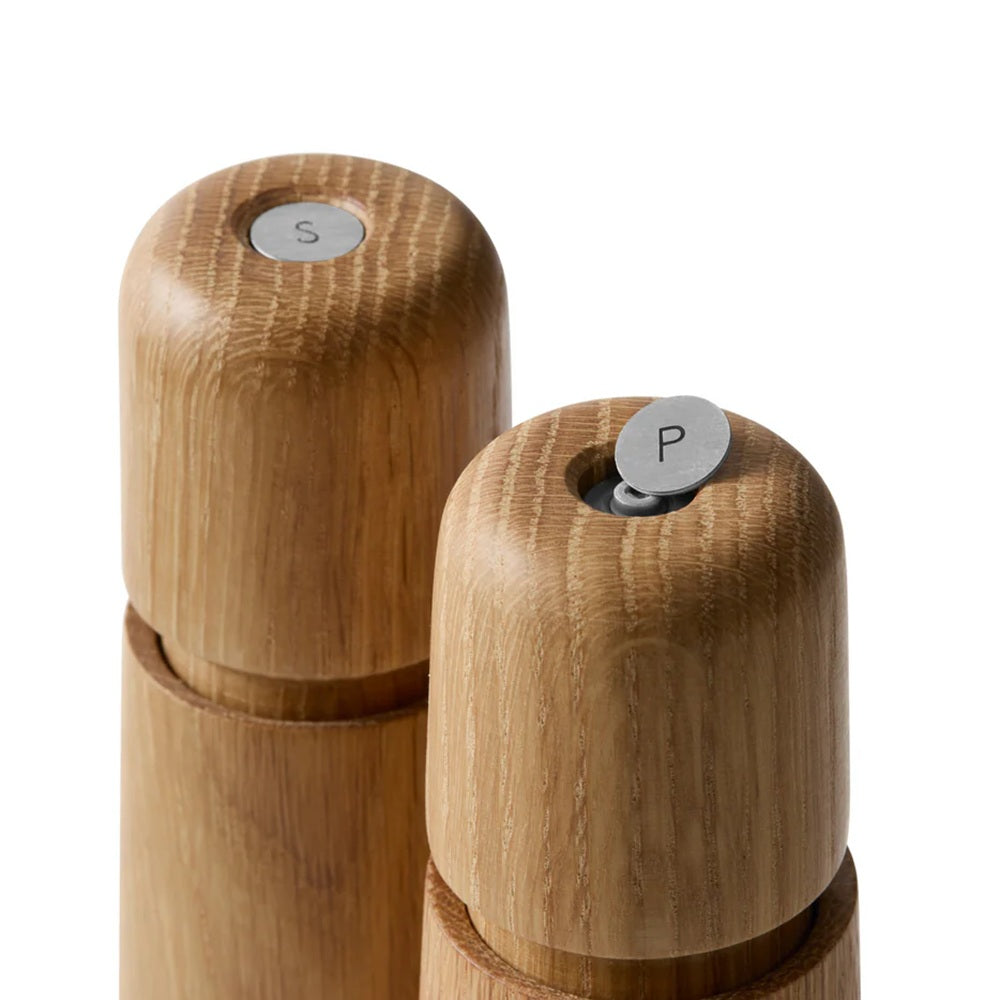 Wooden salt and pepper shakers with 'S' and 'P' labels on a white background