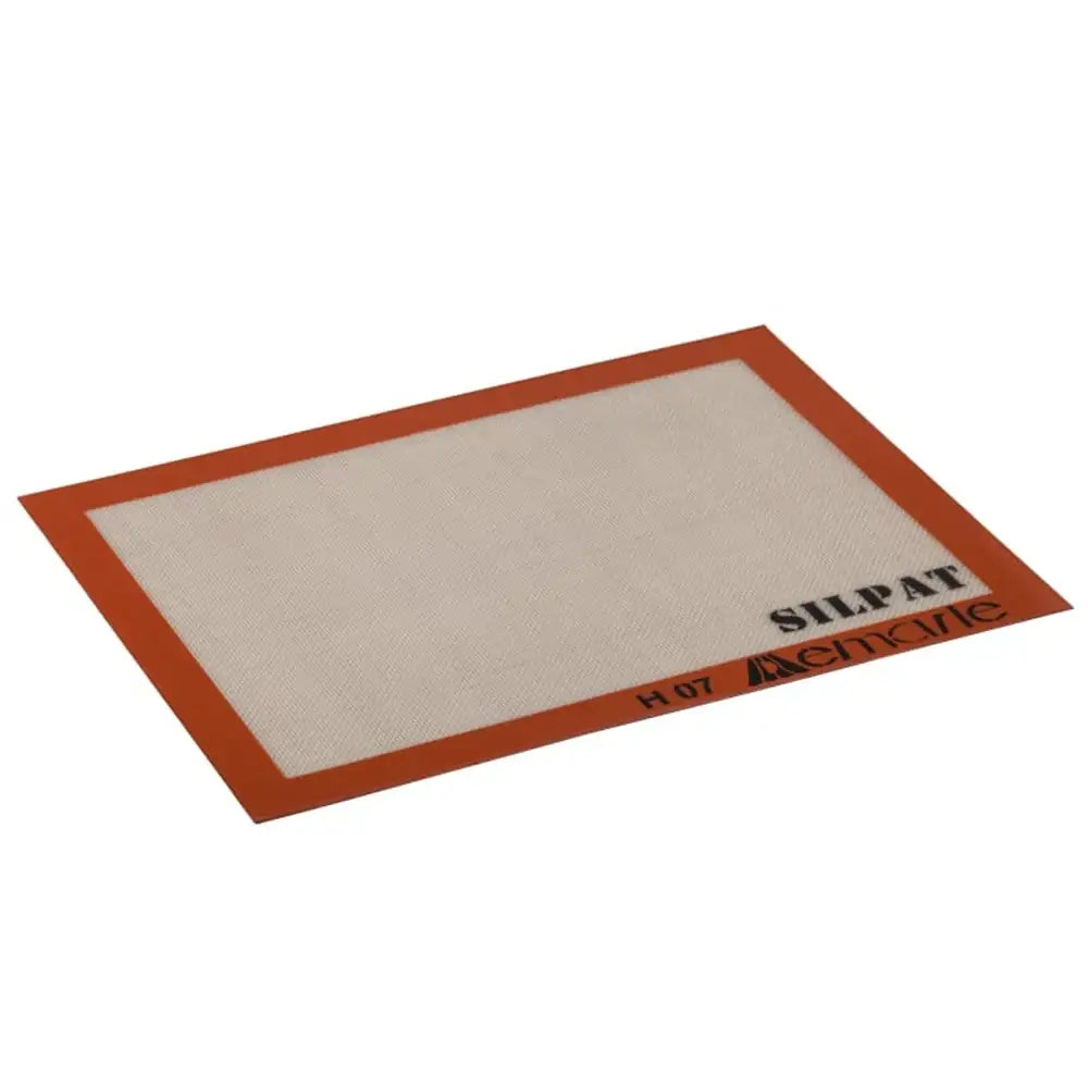 Silicone baking mat with red border and 'Silpat' branding on a white background