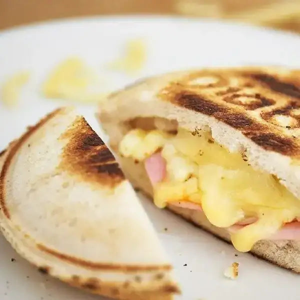 Toasted jaffle with melted cheese and ham filling on a white plate, Cookin Stores kitchenware
