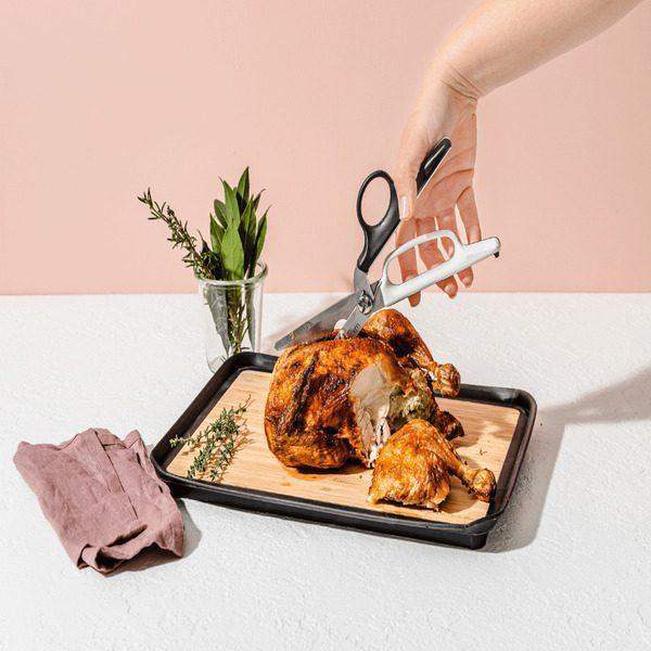 Dreamfarm Bishears kitchen scissors cutting roast chicken on a tray, kitchenware at Cookin Stores