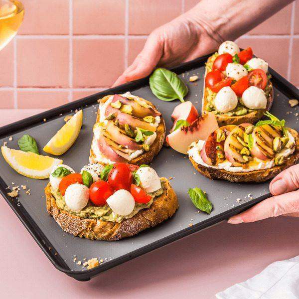 Dreamfarm Big Fledge black cutting board with gourmet toast, mozzarella, tomatoes, and basil, Cookin Stores kitchenware
