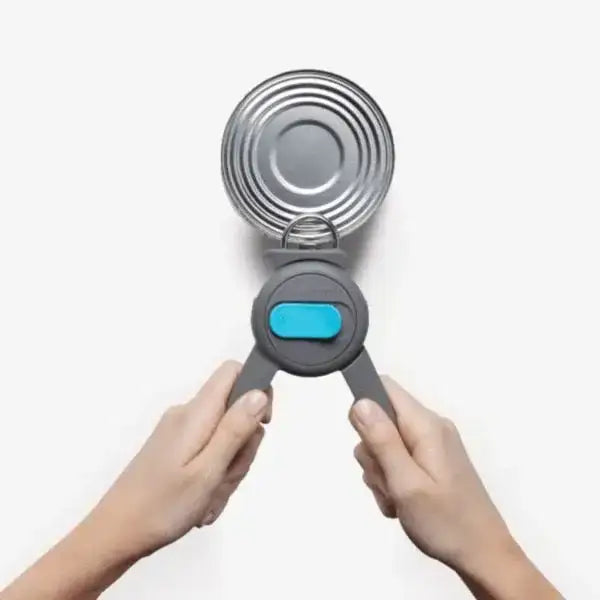 Hands using Dreamfarm Dopener can opener in grey to open a tin, kitchenware from Cookin Stores