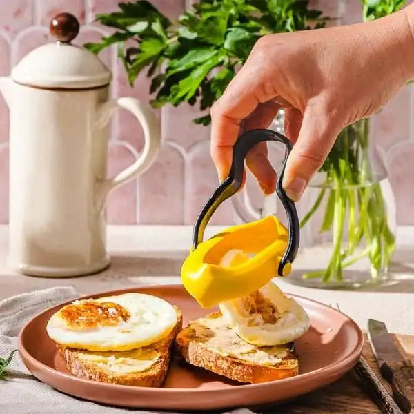 Hand using Dreamfarm Flegg egg flipper to serve fried eggs on toast in a kitchen setting