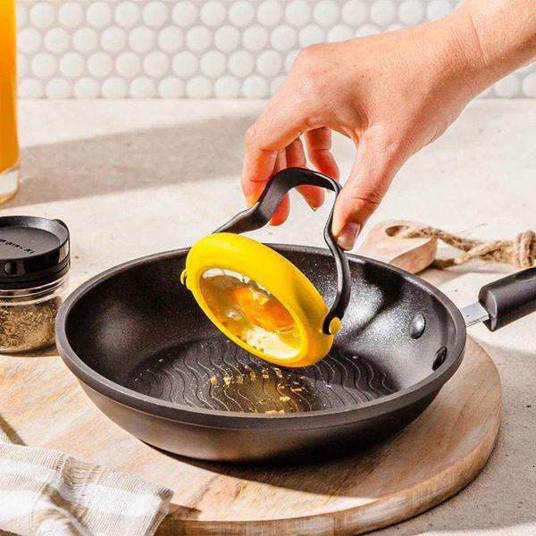 Hand holding Dreamfarm Flegg egg tool over frying pan, premium kitchenware at Cookin Stores