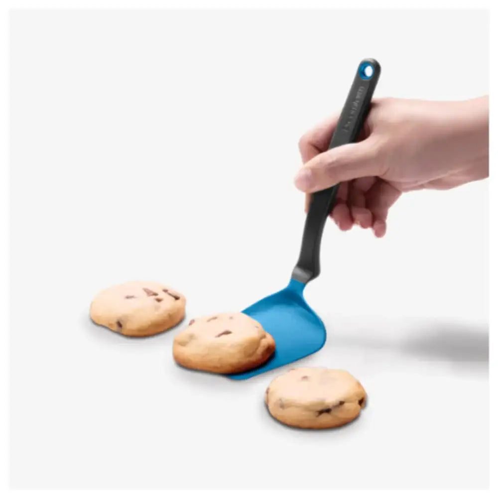 Blue spatula lifting cookies from a baking sheet