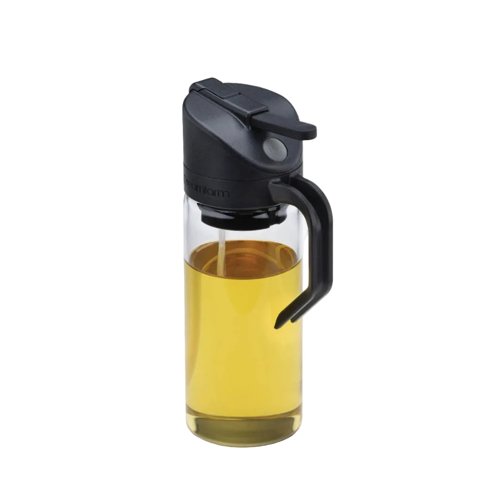 Glass bottle with black cap and handle filled with a yellow liquid on a white background