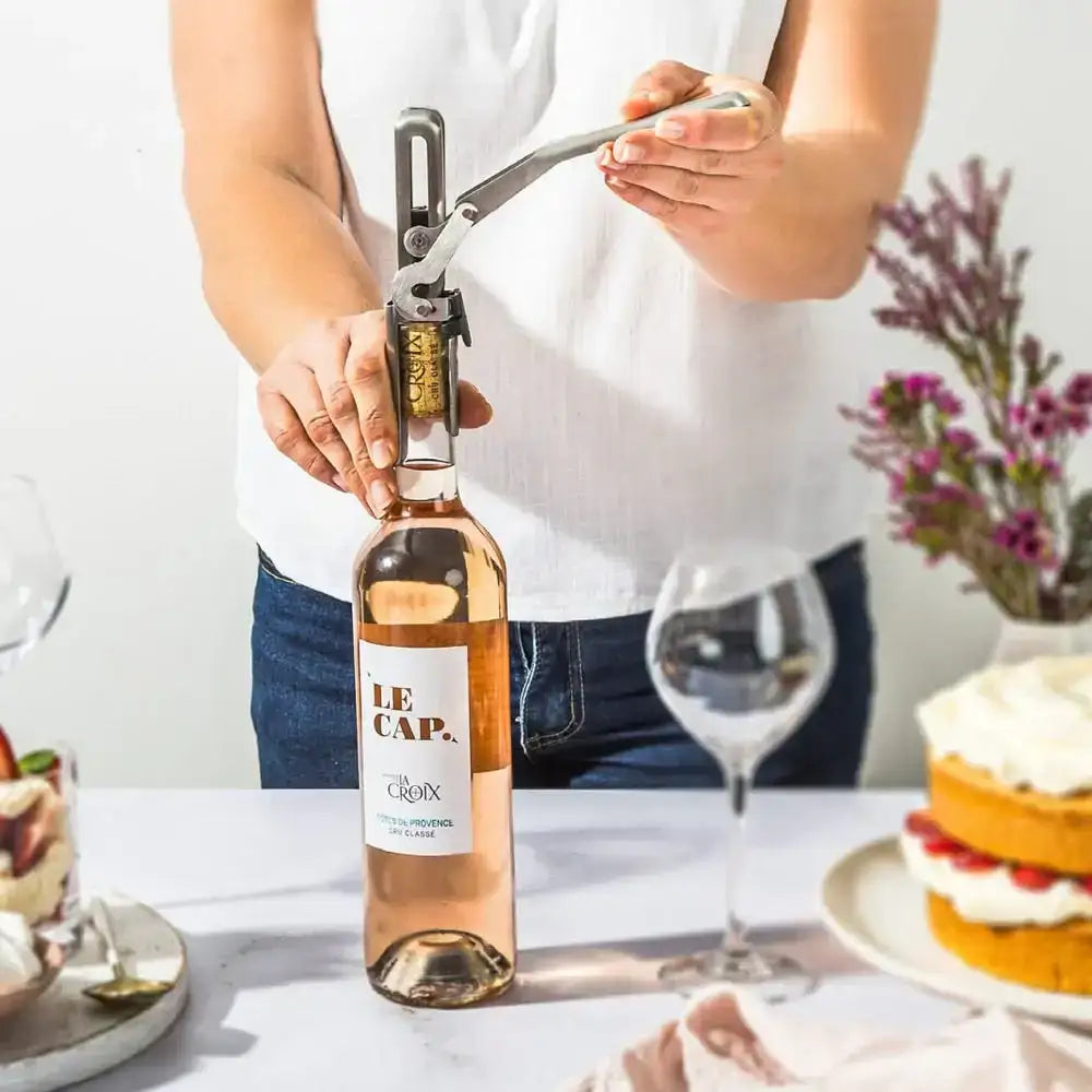 Opening a wine bottle with a Dreamfarm mechanical wine opener on a kitchen table at Cookin Stores