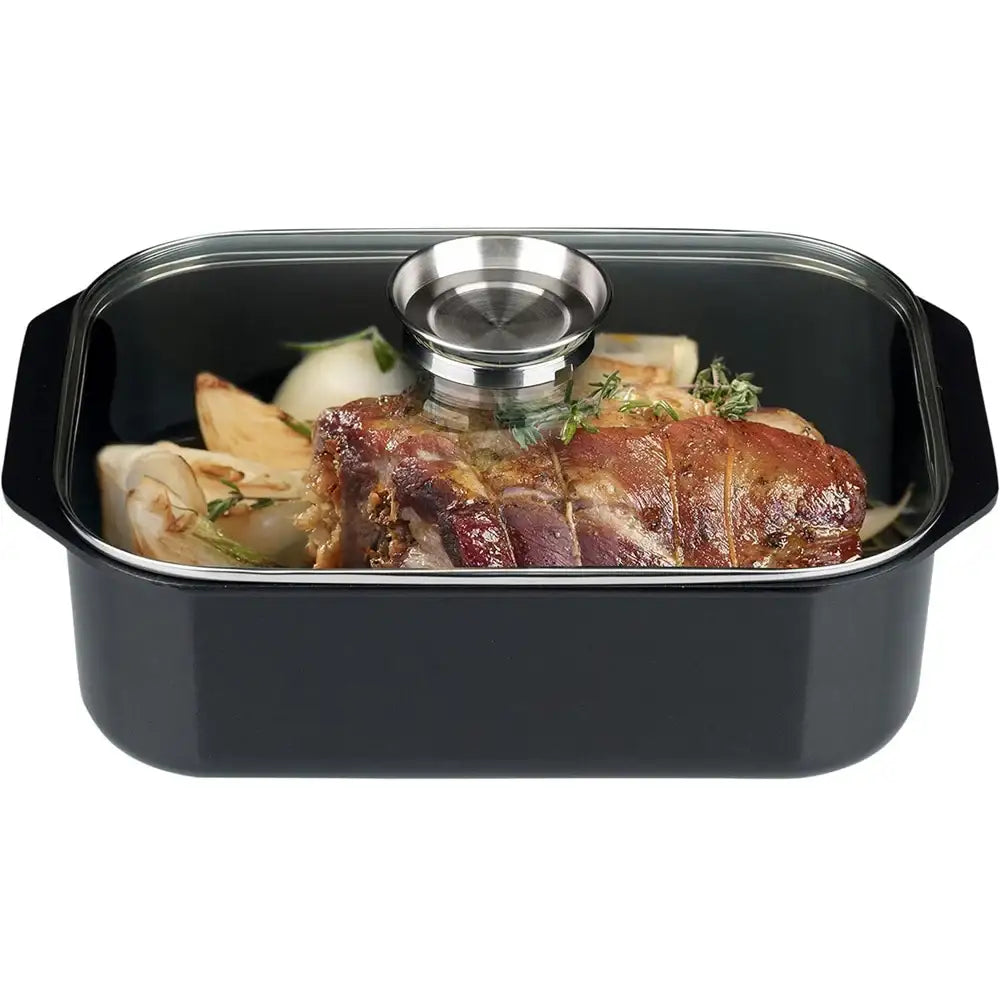Black roasting dish with a lid containing roasted meat and vegetables on a white background