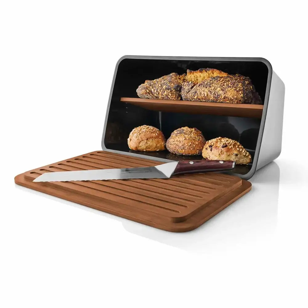 Bread bin with wooden cutting board and knife, containing sliced bread on a white background