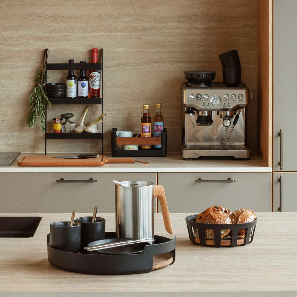 Kitchen counter with coffee machine, bottles, and bread basket.