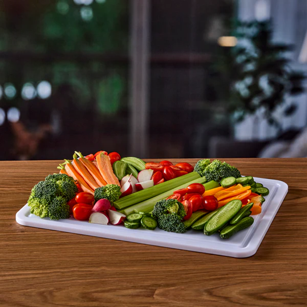 Assorted vegetables on a white cutting board with a blurred background