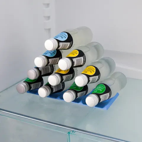 Bottles with labels arranged on a blue mat inside a refrigerator.
