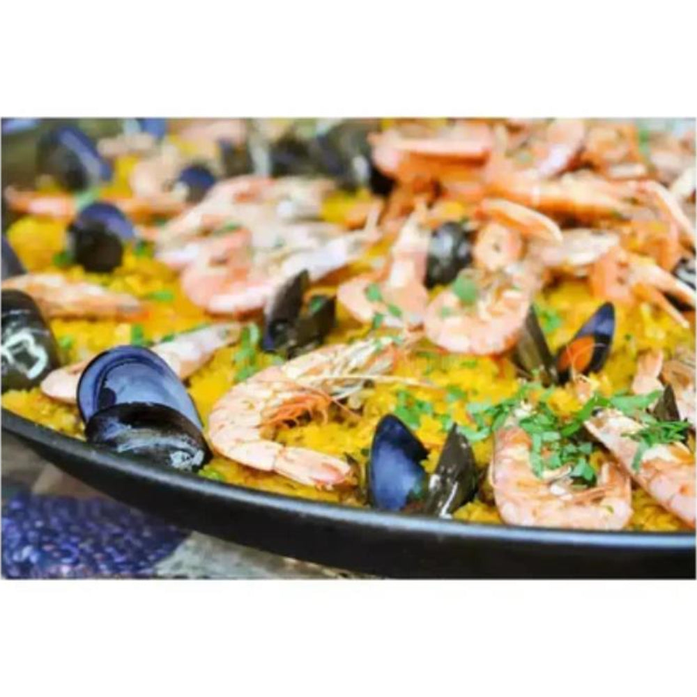 Seafood dish with shrimp and mussels in a pan on a white background