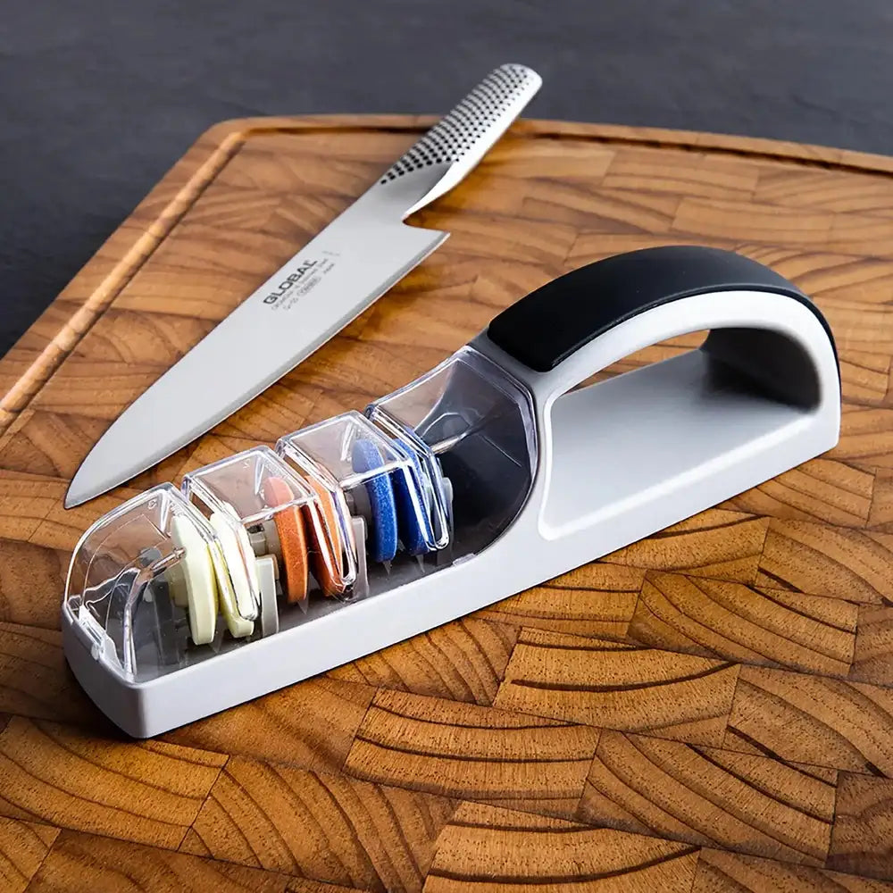 Knife sharpener with a knife on a wooden cutting board