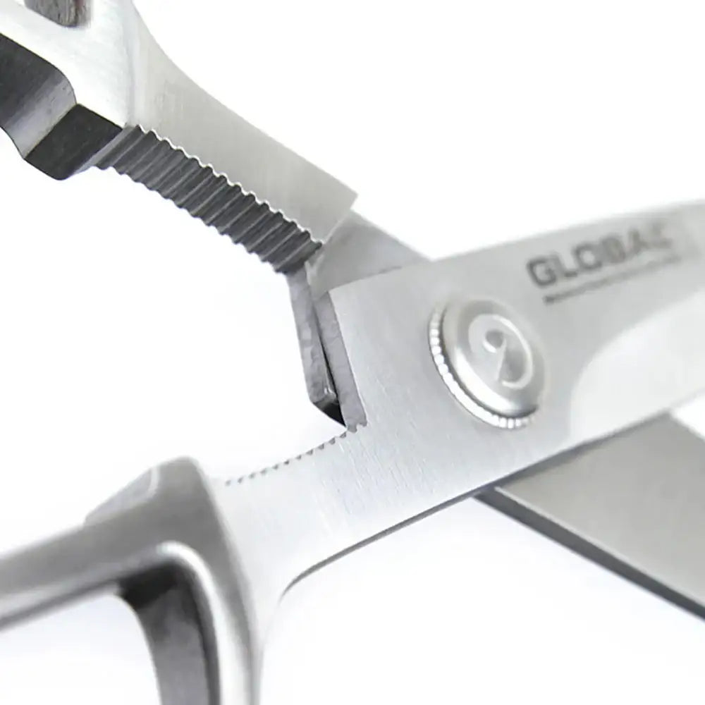 Close-up of a pair of scissors with 'GLOBAL' branding on a white background