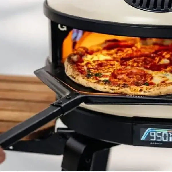 Gozney pizza oven with pepperoni pizza on a placement peel, premium kitchenware at Cookin Stores
